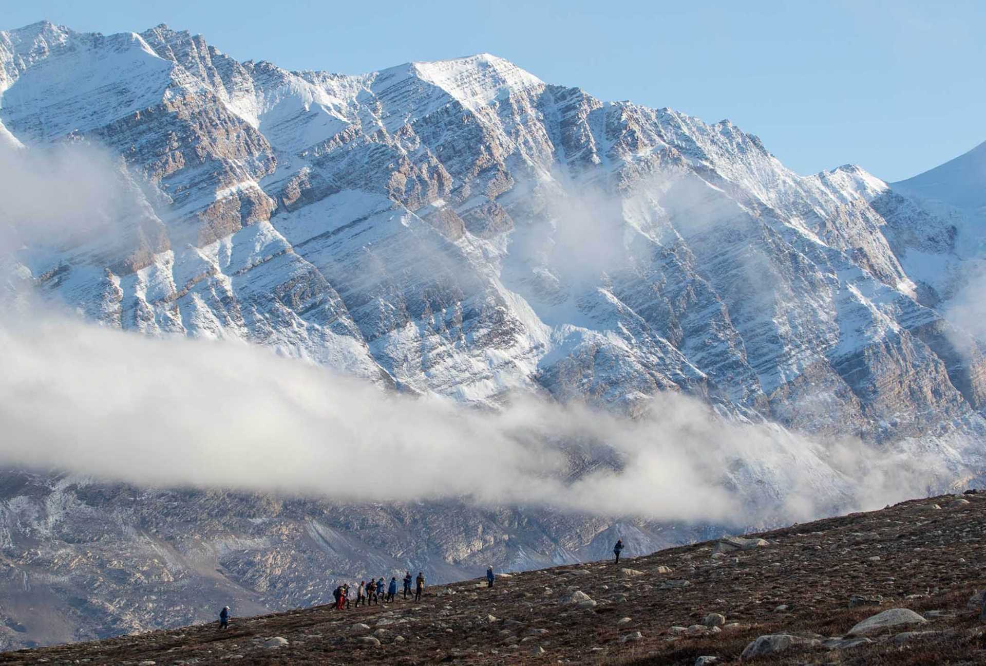 hikers with snowcapped cliffs in background