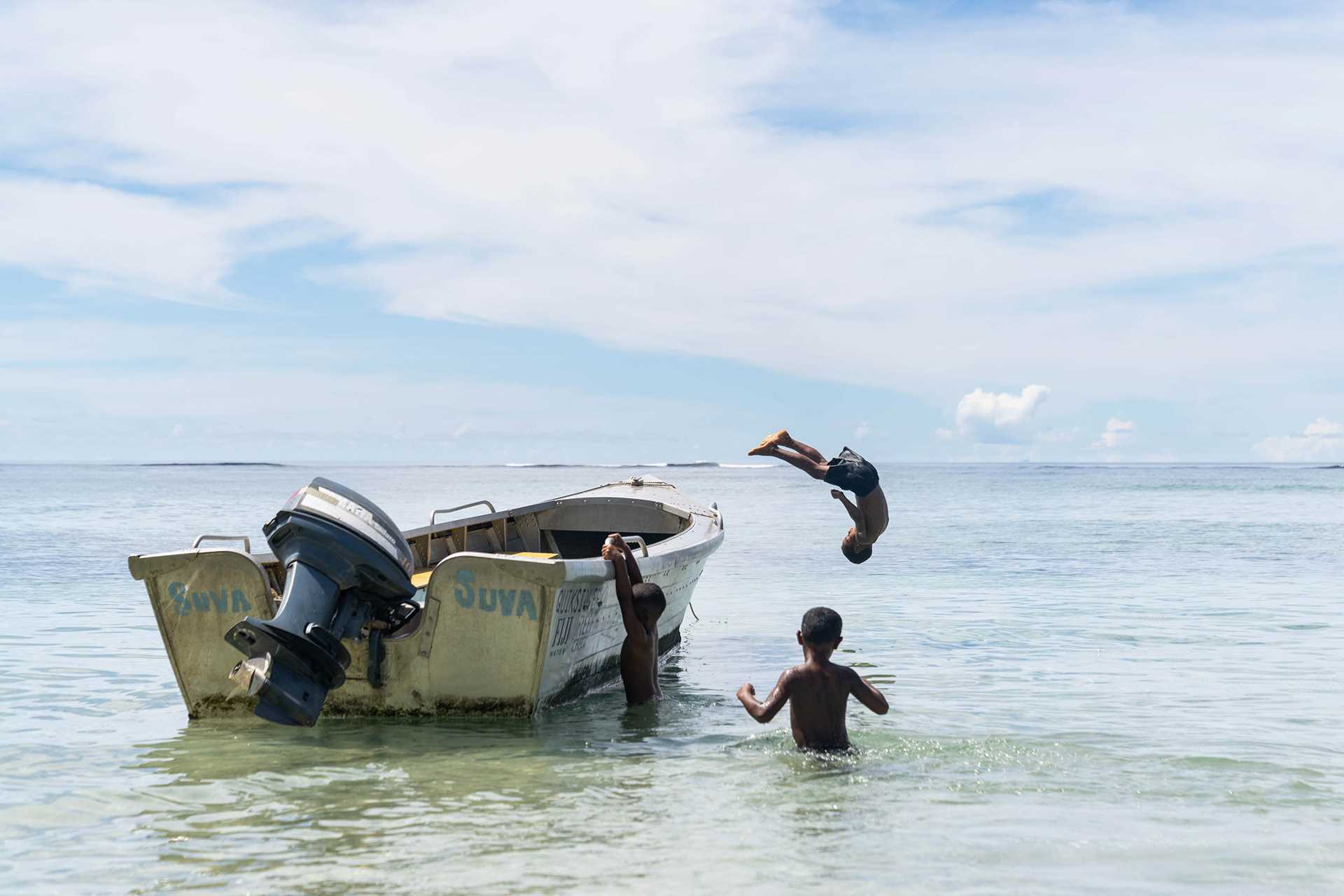 Children leaping off of a boat