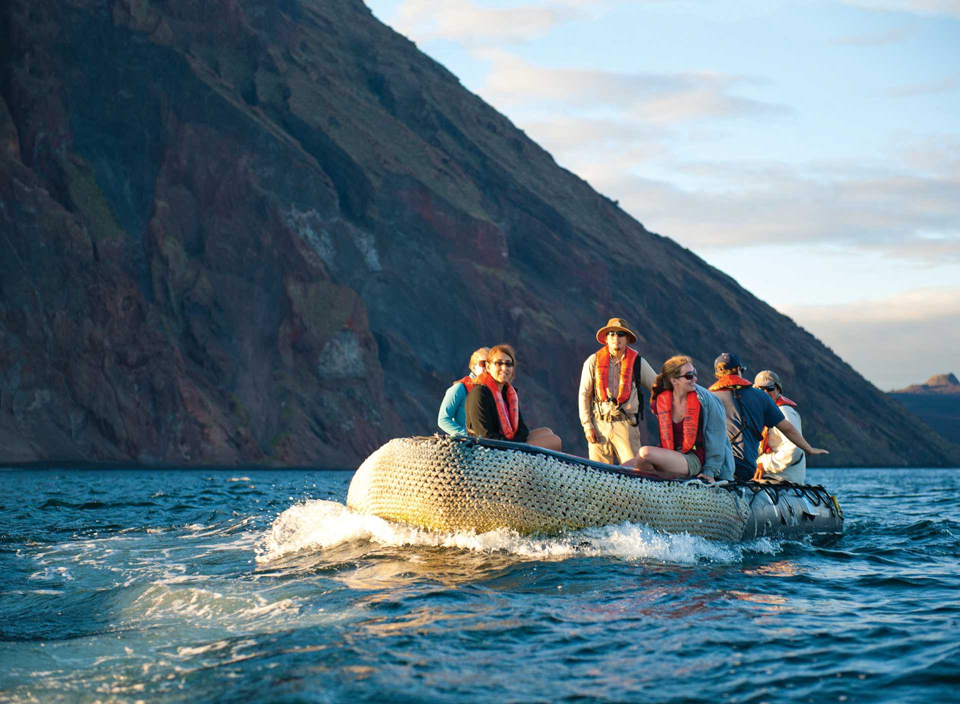 Guests ride on a Zodiac driven by a naturalist, Galápagos.